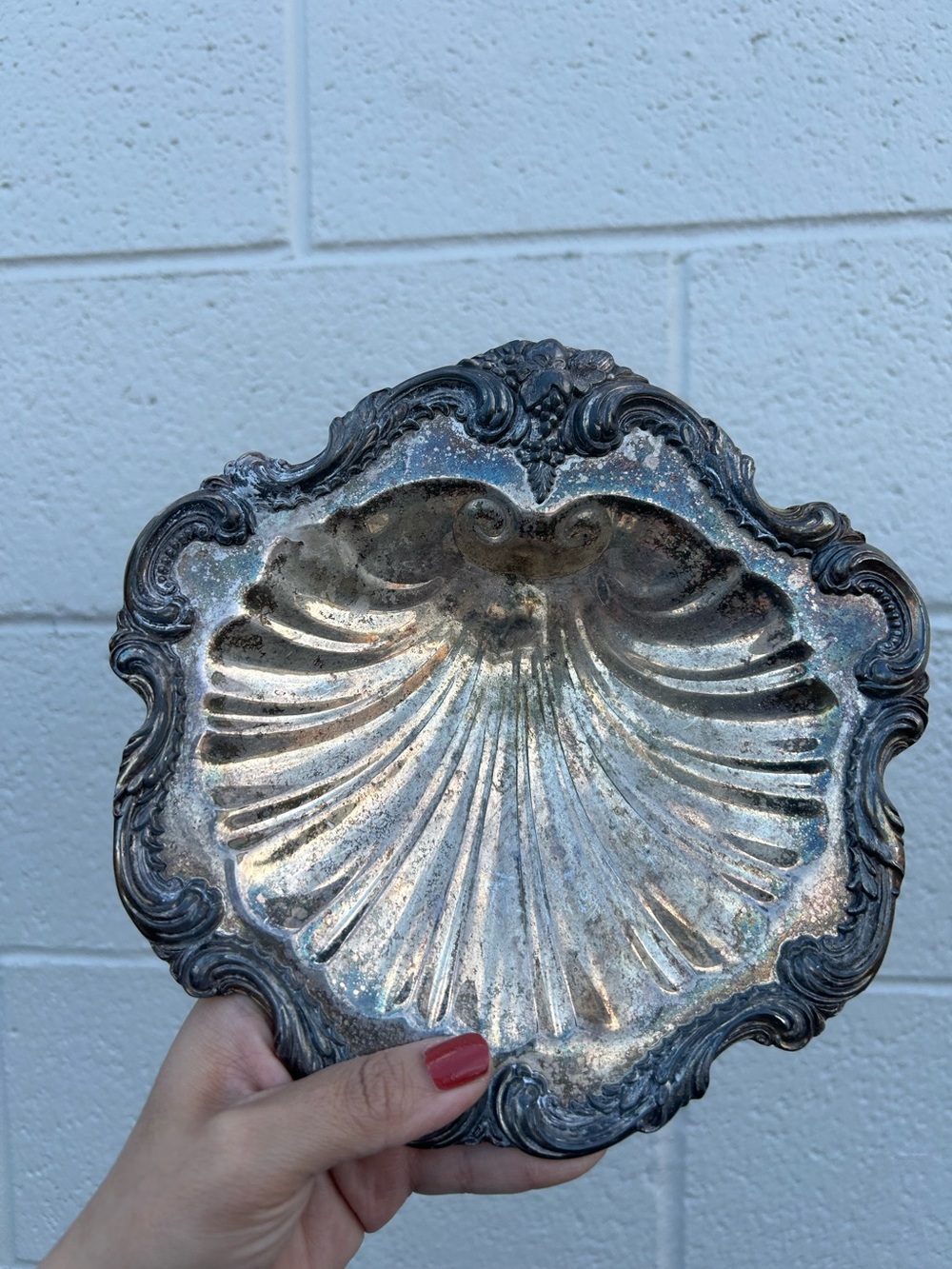 vintage silver-plated shell dish features a scalloped, ornate rim iridescent